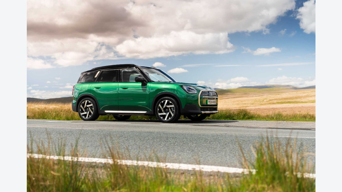 英国向けMINI Countryman Eのグリーンの通常モデルが郊外を走る写真
